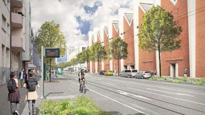 Strassenszene mit Radfahrer und Fussgängern neben Backsteingebäuden und Bäumen