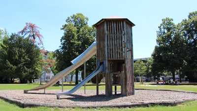 Ein hoher holziger Turm mit zwei Rutschbahnen