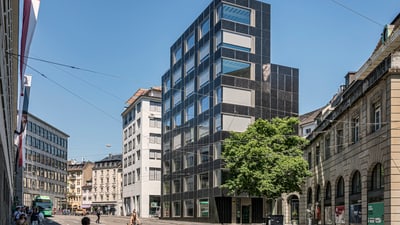 Das Amt für Umwelt und Energie mit Photovoltaikfassade und Baum im Vordergrund