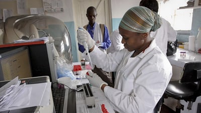 Lab technician measuring liquid in a laboratory.