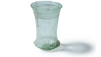 Frühmittelalterlicher Glasbecher auf weissem Hintergrund.