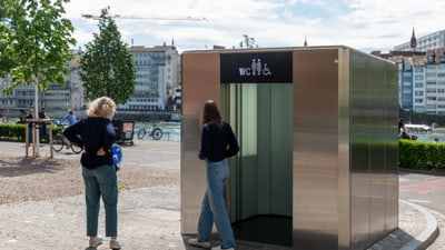 Zwei Personen vor einer öffentlichen Toilette in Basel.