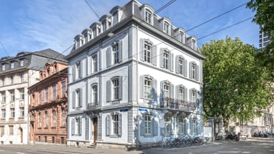 Eckgebäude in historischer Strasse bei Tageslicht.