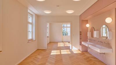 Heller Innenraum mit Waschbecken und Parkettboden.