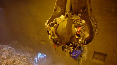 Greifer voller Müll in einer Abfallanlage.