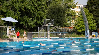 Städtisches Freibad mit Schwimmern und Badewächter.