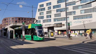 Grünes Tram an der Haltestelle vor dem Voltacenter-Gebäude.