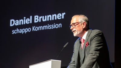 Mann am Rednerpult bei einer Veranstaltung.