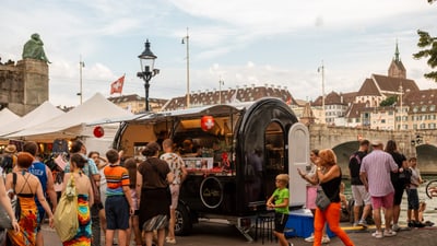 People at a street market with vendor stalls.