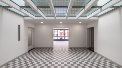 Moderner Raum mit kariertem Boden und Glaselementen an der Decke.