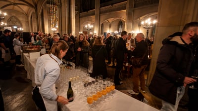 Menschen stehen von dem gedeckten Apéro-Tisch und tauschen sich aus