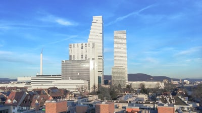 Skyline der Roche Türme und Wohnhäusern im Vordergrund.