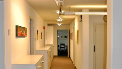 Langer, heller Flur mit Kunstwerken an den Wänden.