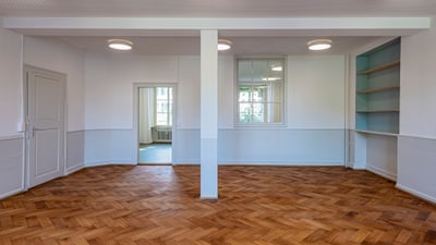 Leerer Raum mit Holzfussboden und Regalen.