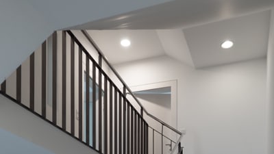 Treppenhaus mit Treppengeländer aus Metall und Downlights an der Decke