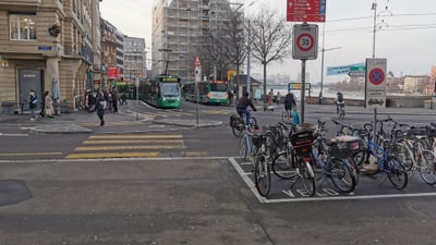 Strassenszene mit Strassenbahnen und Fahrrädern in Basel.