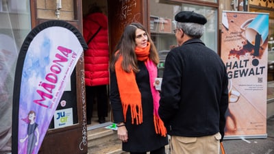 Regierungsrätin Stephanie Eymann vor dem Mädchentreff Mädona im Gespräch mit einem Passanten.