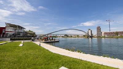 Rhein mit Uferweg und im Hintergrund die Brücke nach Deutschland.