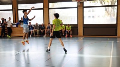 Basketballspieler springt für einen Wurf in der Halle.