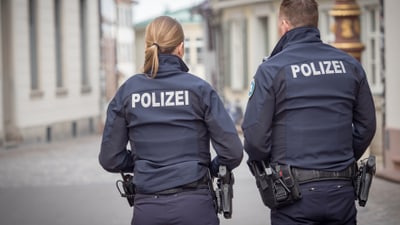 Zwei Polizisten patrouillieren auf der Strasse