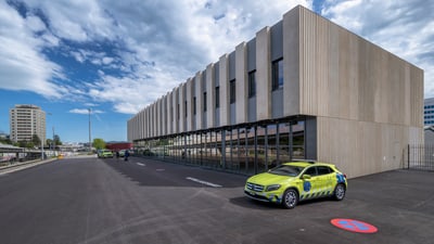 Modernes Gebäude mit einem Rettungswagen davor.