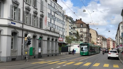 Strassenbahngleise und Gebäude in einer Stadtstrasse.