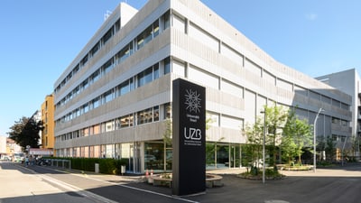 Grosses Gebäude davor eine Tafel mit dem Logo der Uni Basel und der Aufschrift UZB.