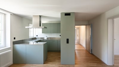 Moderne Küche mit Holzfussboden und grauer Ausstattung.