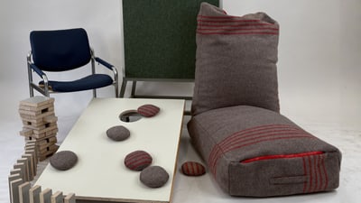 Modernes Wohnzimmer mit Stuhl, Kissen und Brettspiel.