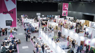 Innenansicht einer Designmesse "BLICKFANG" mit Ständen und Besuchern.