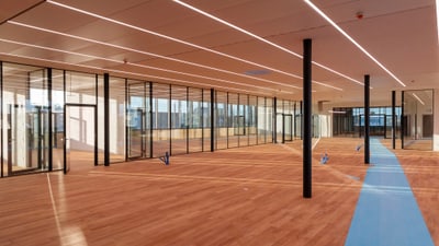 Leerer Raum mit Holzboden und Glaswänden.