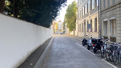 Strassenszene mit Fahrrädern und Motorrädern geparkt in einer Gasse.