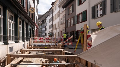 Strassenszene mit dem Team der Archäologischen Bodenforschung bei einer Baustelle.