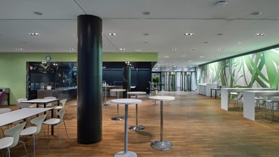 Mensa mit Tischen und Stühlen.