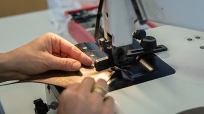 Person näht Stoff an einer Maschine.