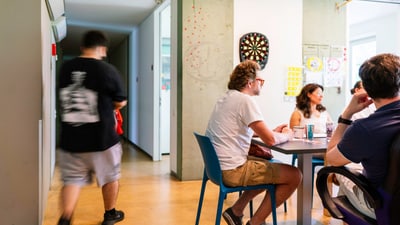 Menschen in einem Büro sitzen an einem Tisch und tauschen sich aus.