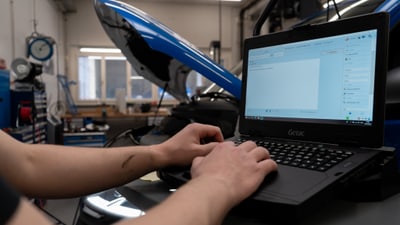 Mechaniker benutzt Laptop in Werkstatt.