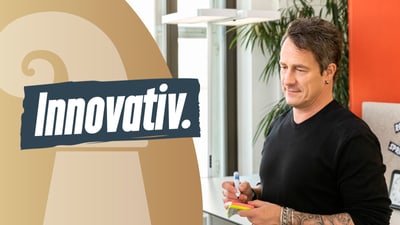 Mann mit Stift und Notizzettel, Text 'Innovativ.'