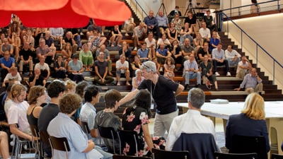 Person hält Vortrag vor Publikum in einem Auditorium.