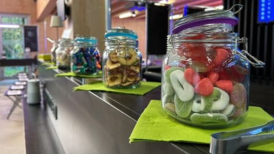 Reihe von Glasgefässen mit Süssigkeiten auf einer Theke.