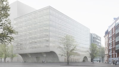 Modernes Gebäude mit Glasfassade und Bäumen in der Stadt.