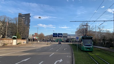 Strasse mit Strassenbahn und Autos am Berner Stadtrand.