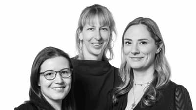 Drei Frauen posieren zusammen in Schwarz-Weiss-Bild.