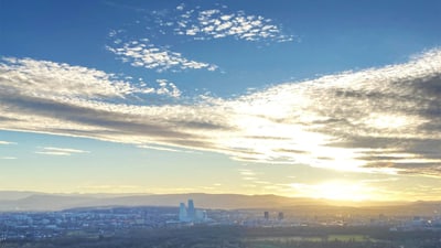 Sonnenuntergang über Stadt mit Wolkenhimmel.