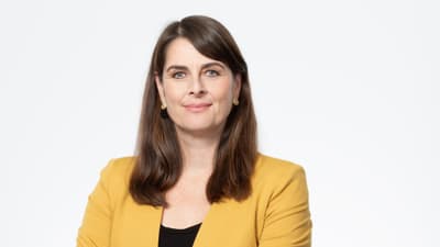 Regierungsrätin Stephanie Eymann in gelbem Blazer vor weissem Hintergrund.