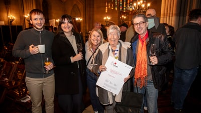 Gruppe von fünf Menschen bei Veranstaltung mit Getränken und Zertifikat.