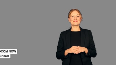 Eine Frau mit hochgesteckten Haaren ist in einem schwarzen Oberteil und schwarzen Blazer sichtbar. Auf der linken Seite steht "PROCOM NOW im Einsatz"
