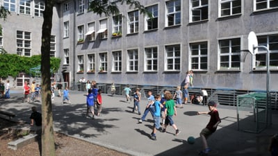 Kinder spielen auf dem Schulhof des Peters-Schulhauses.