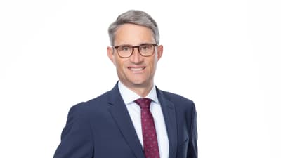 Portrait von Regierungsrat Lukas Engelberger in blauem Anzug und roter Kravatte.