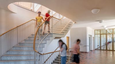 Personen gehen eine Treppe in einem Gebäude hinunter.